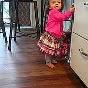 Nena joined the competition — help win amazing prizes! barefoot, cabinet, chair, child, curtain, expression, flooring, furniture, hair_clip, holding, home, indoor, kitchen, person, pink_sweater, plaid_skirt, standing, toddler, wooden_floor, young_child
