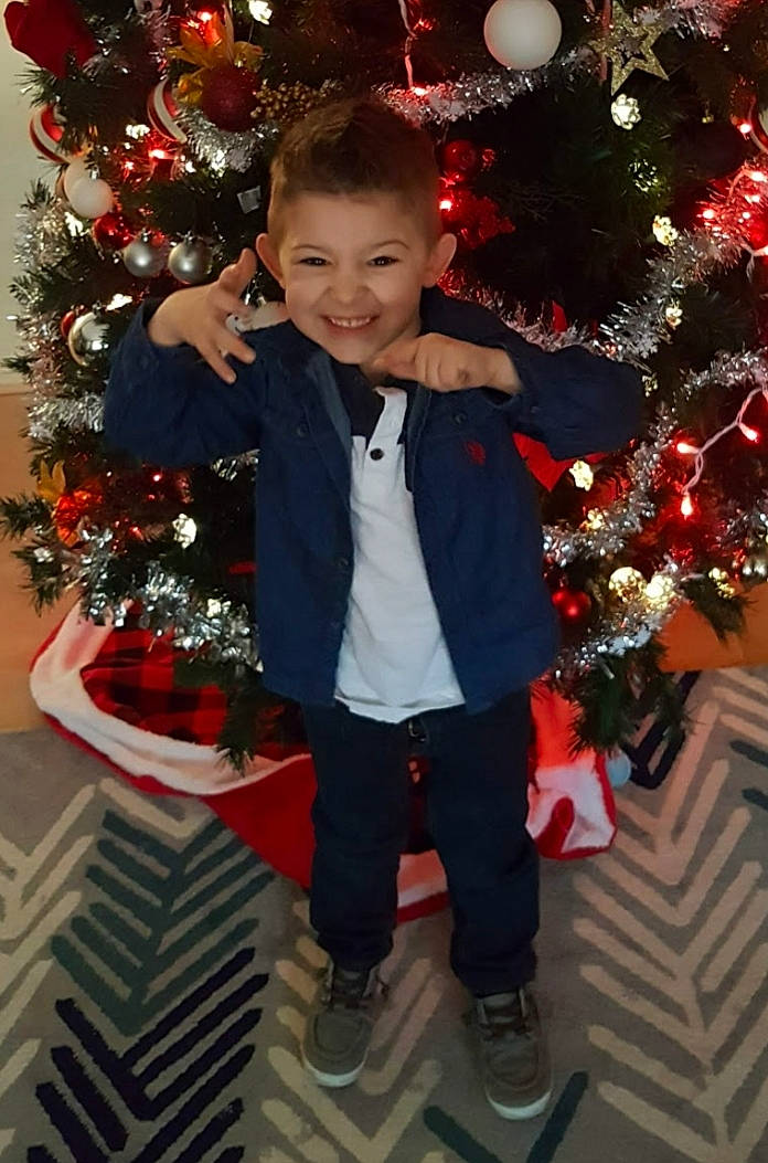 Elijah joined the competition — help win amazing prizes! child, christmas, christmas_decoration, christmas_eve, christmas_lights, christmas_ornament, christmas_tree, event, fir, holiday, holiday_ornament, interior_design, joy, outerwear, person, pine_family, plant, smile, standing, toddler