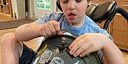 Raven joined the competition — help win amazing prizes! child, boy, wheelchair, indoor, bucket, halloween, pumpkin, tombstone, decorations, wooden_floor, cabinet, light, window, door, shorts, blue_shirt, furniture, person, curtains, plastic_bucket
