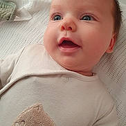 Harrison is registered to the contest to win money with this photo: baby, infant, face, eyes, mouth, onesie, clothing, bear_patch, blanket, texture, cute, smiling, child, person, portrait, indoor, skin, head, happy, closeup