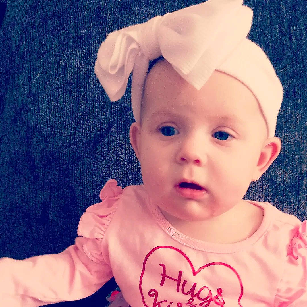Madelyn is registered to the contest to win money with this photo: baby, baby_toddler_clothing, cap, cheek, child, costume_hat, ear, electric_blue, eyelash, face, fashion_accessory, gesture, happy, headband, pattern, person, pink, skin, sleeve, smile