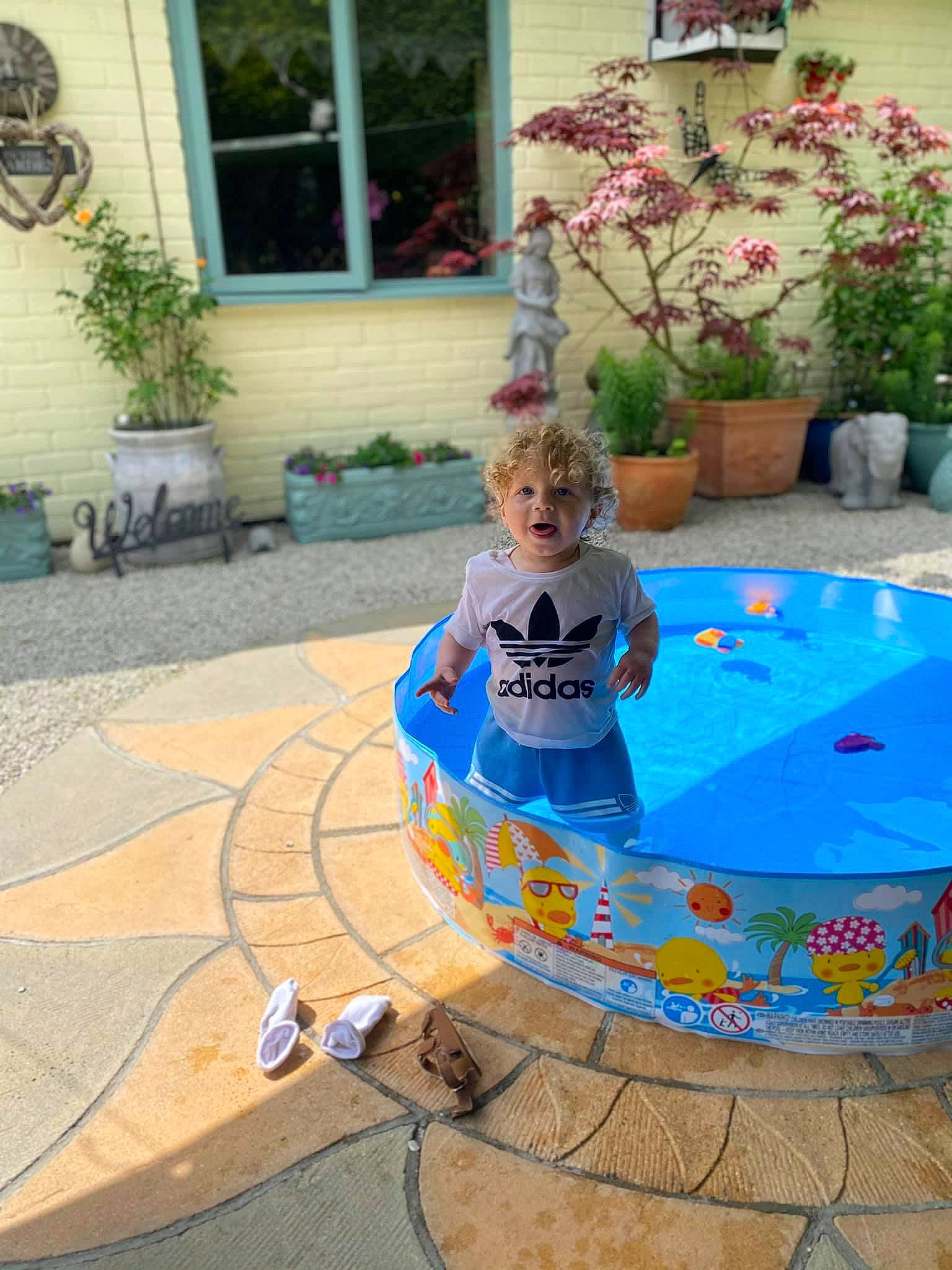 Kobie joined the competition — help win amazing prizes! bathing, child, electric_blue, flagstone, flooring, flower, flowerpot, fun, games, garden, grass, houseplant, leisure, person, plant, recreation, shorts, swimming_pool, toddler, water