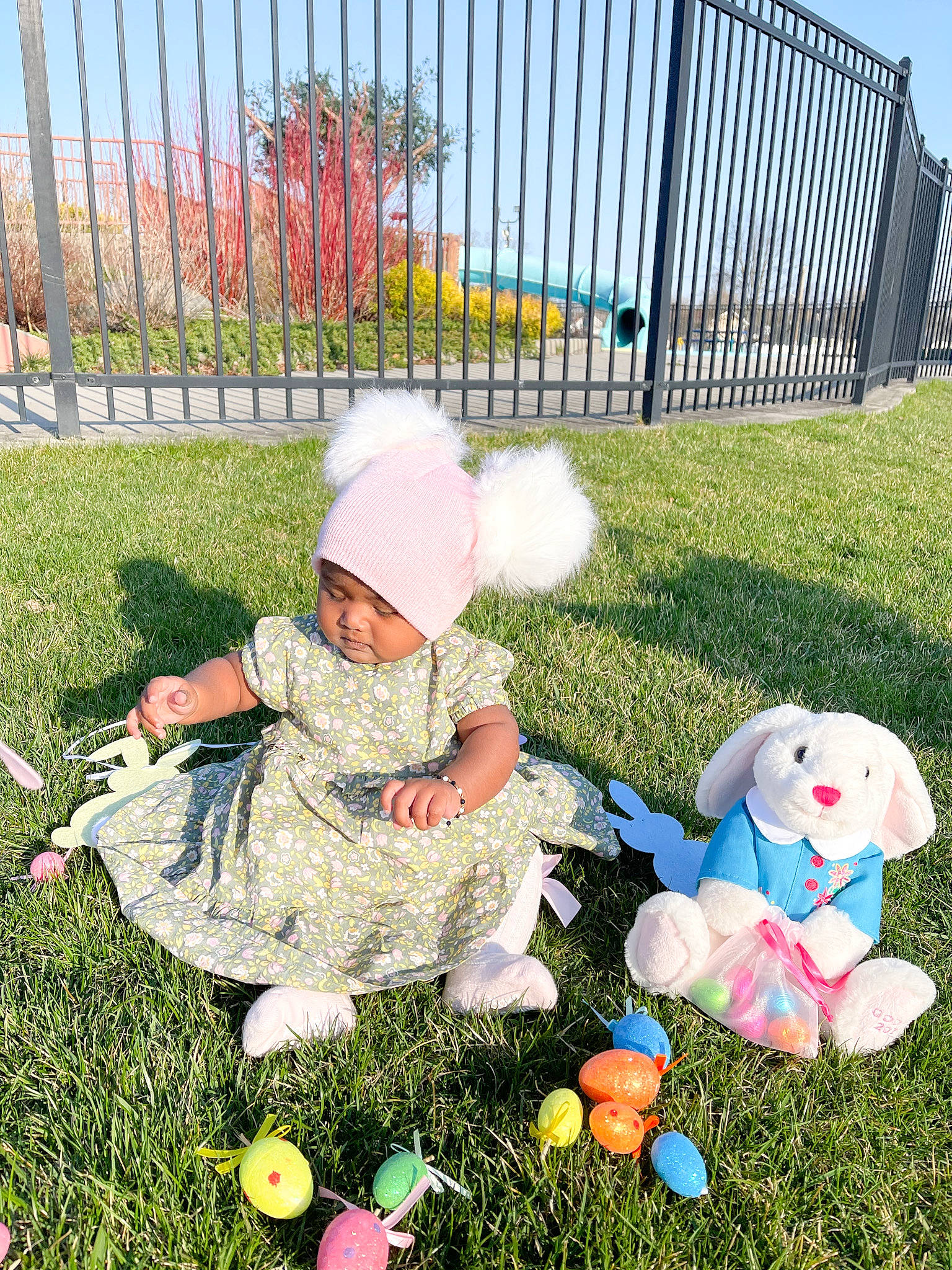 Kelsey is registered to the contest to win money with this photo: baby, baby_toddler_clothing, child, fence, fun, grass, grass_family, green, hat, headwear, lawn, leisure, outdoor_furniture, people_in_nature, person, plant, recreation, sky, sports_equipment, summer