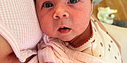 Nancy is registered to the contest to win money with this photo: baby, newborn, infant, child, pink, blanket, close_up, face, eyes, skin, person, holding, caring, soft, comfort, indoor, clothing, fabric, parent, love