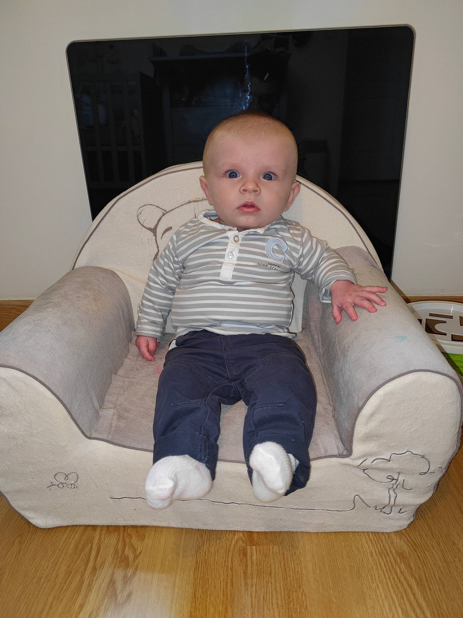 Malonn participe au concours pour gagner de l'argent avec cette photo : baby, baby_products, baby_toddler_clothing, chair, child, comfort, couch, floor, flooring, foot, human_body, human_leg, knee, person, sitting, sleeve, sock, t_shirt, thigh, toddler