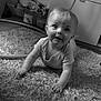 Elijah is registered to the contest to win money with this photo: baby, child, crawling, carpet, indoor, black_and_white, curious, smiling, infant, toy, floor, person, home, young, cute, portrait, expression, soft_light, carpet_texture, toddler