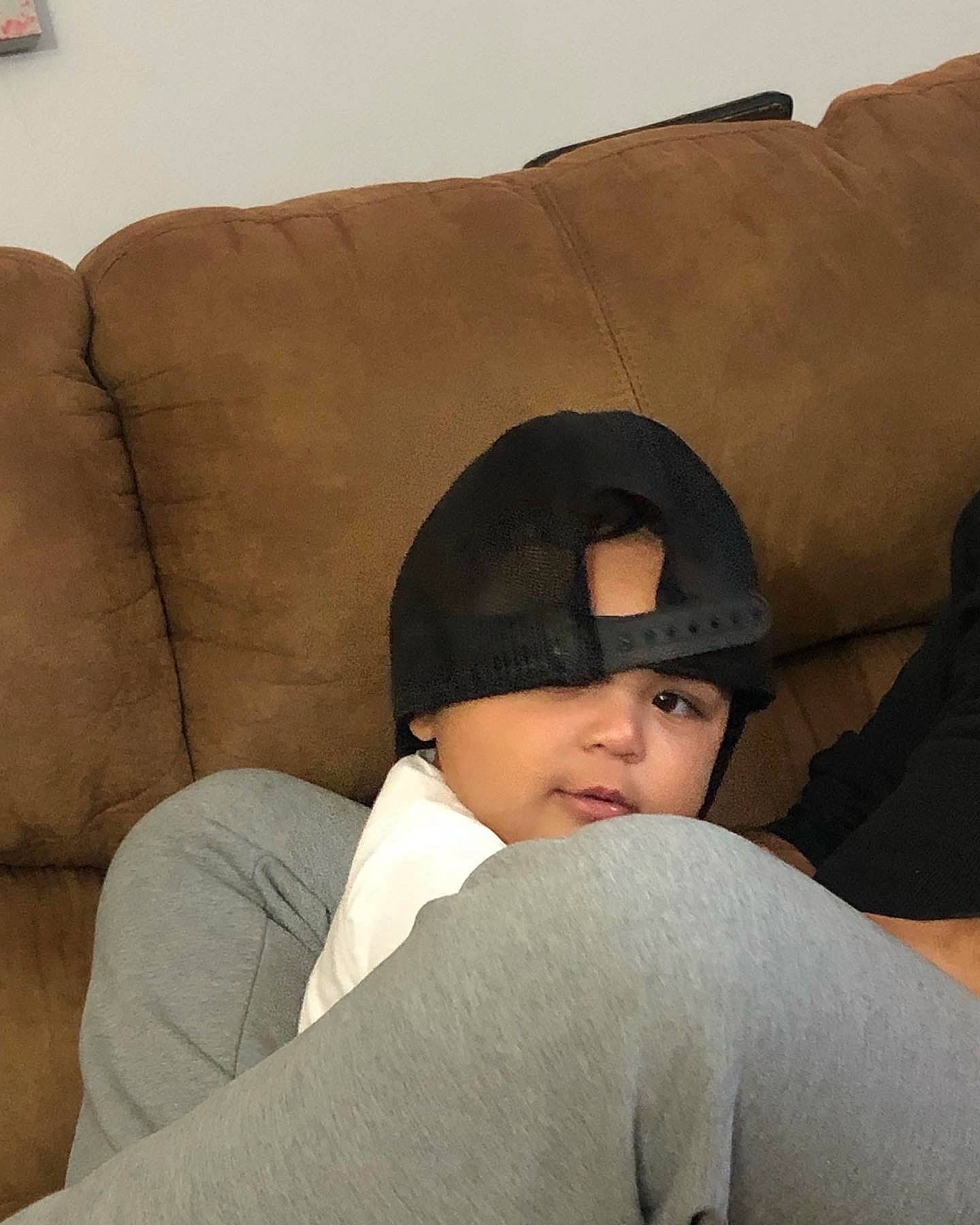 Malachi joined the competition — help win amazing prizes! baby, cap, child, comfort, couch, eyewear, fun, fur, headgear, headwear, human_leg, linens, nap, neck, person, room, sitting, sleep, sunglasses, throw_pillow