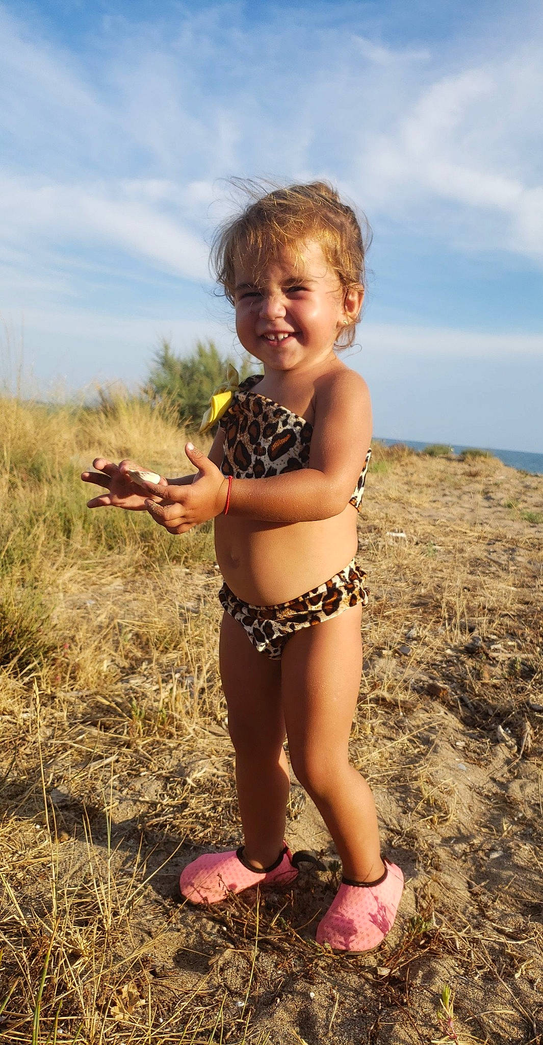 Saona participe au concours pour gagner de l'argent avec cette photo : beach, blond, cloud, fun, gesture, grass, hair, happy, human_leg, joy, landscape, people_in_nature, person, plant, sand, sky, smile, swimwear, thigh, thumb