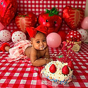 Azari is registered to the contest to win money with this photo: baby, child, cake, strawberry, balloon, red_bow, checkered_tablecloth, birthday, celebration, cream, sprinkles, decorations, cute, messy, smiling, face, hands, pink_balloon, heart_balloon, photography