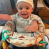 baby, child, infant, hat, smiling, happy, toy, baby_seat, indoor, furniture, colorful, clothing, person, play, cute, young, seat, expression, hand, face
