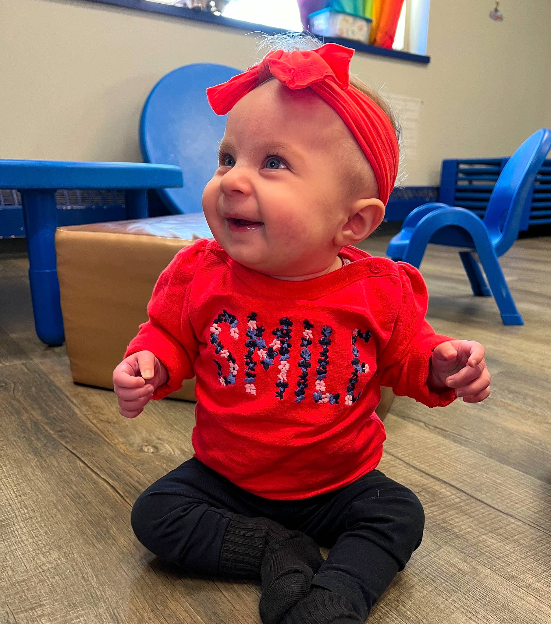 Veronica is registered to the contest to win money with this photo: baby, baby_toddler_clothing, blue, cap, chair, child, electric_blue, face, flooring, fun, happy, hardwood, head, pattern, person, sitting, sleeve, smile, t_shirt, toddler