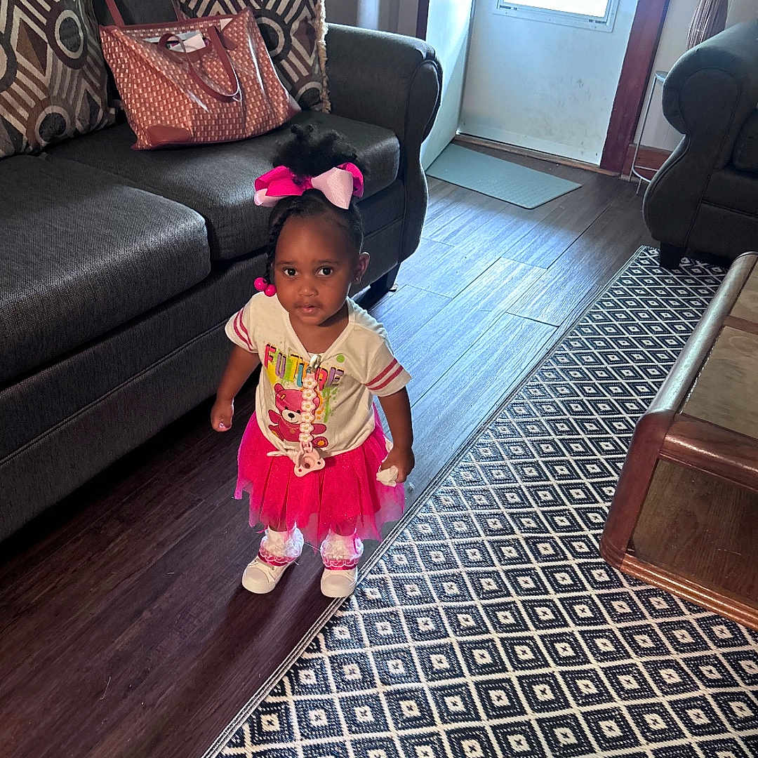 Ahla joined the competition — help win amazing prizes! child, toddler, girl, living_room, sofa, pillow, handbag, pink_bow, tutu, white_shirt, floor_rug, wood_floor, door, carpet, table, home_interior, shoes, standing, cute, portrait