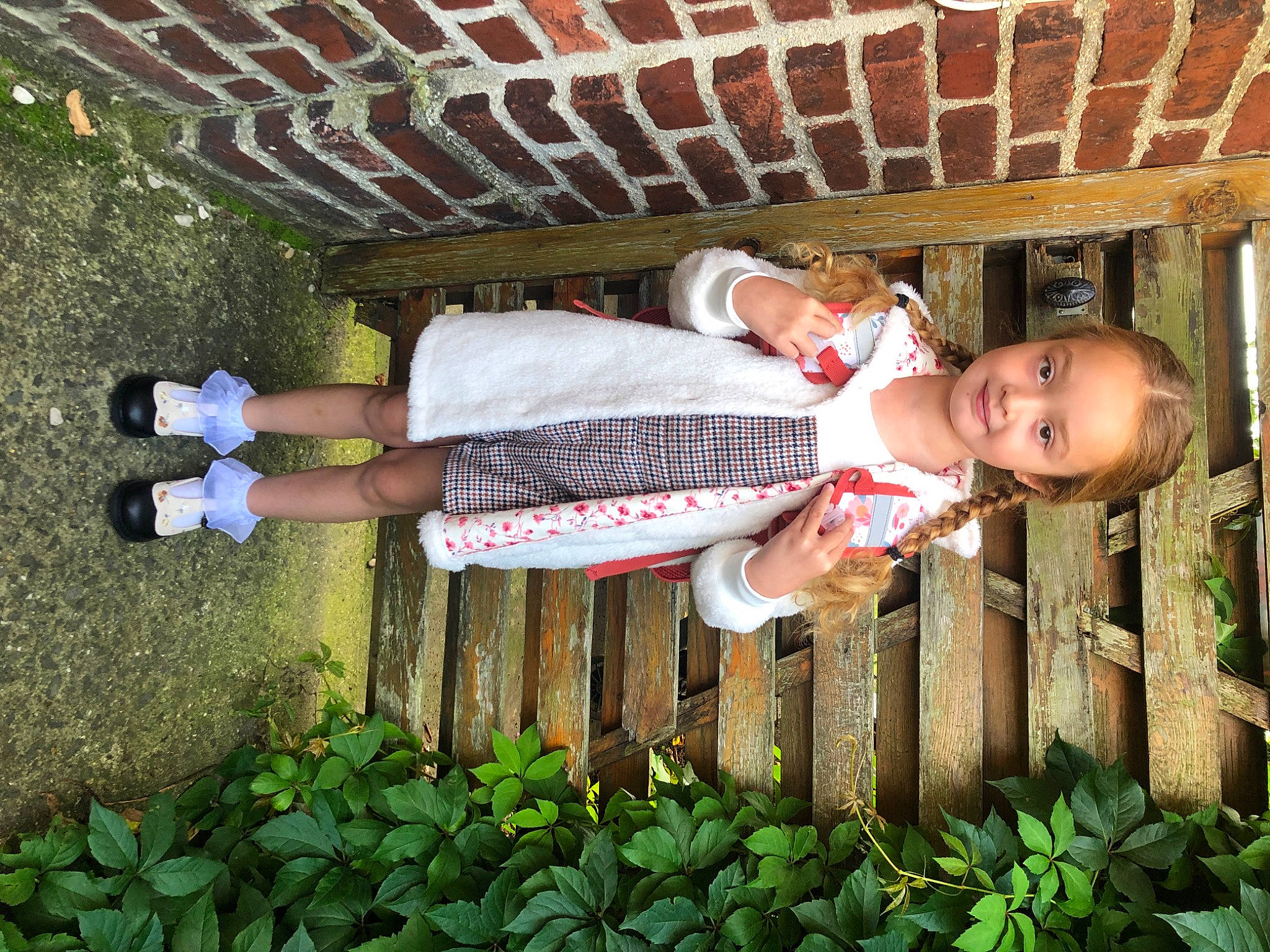 Loona participe au concours pour gagner de l'argent avec cette photo : baby, baby_toddler_clothing, brick, brickwork, child, fence, fun, grass, happy, human_leg, joy, leisure, pattern, people_in_nature, person, plant, sitting, thigh, toddler, wood