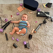 Thessa a rejoint le concours — aidez-le/la à gagner de superbes lots ! baby, child, infant, rug, hair_curlers, hair_styling_tools, flat_iron, makeup, lipstick, cosmetics, curly_hair_tools, plush_rug, floor_tiles, diaper, colorful_clothing, baby_girl, beauty_products, black_box, purple_curlers, cute