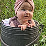 baby, child, bucket, pink_turban, grass, wildflowers, outdoor, nature, greenery, cute, infant, portrait, curious, hands, face, headwear, summer, garden, playful, adorable
