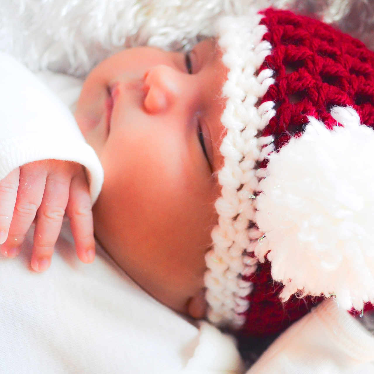 Jovina is registered to the contest to win money with this photo: baby, blanket, child, close_up, cozy, cute, hand, hat, infant, knitted, outfit, peaceful, pom_pom, portrait, red, sleeping, snowflake, soft, warm, white
