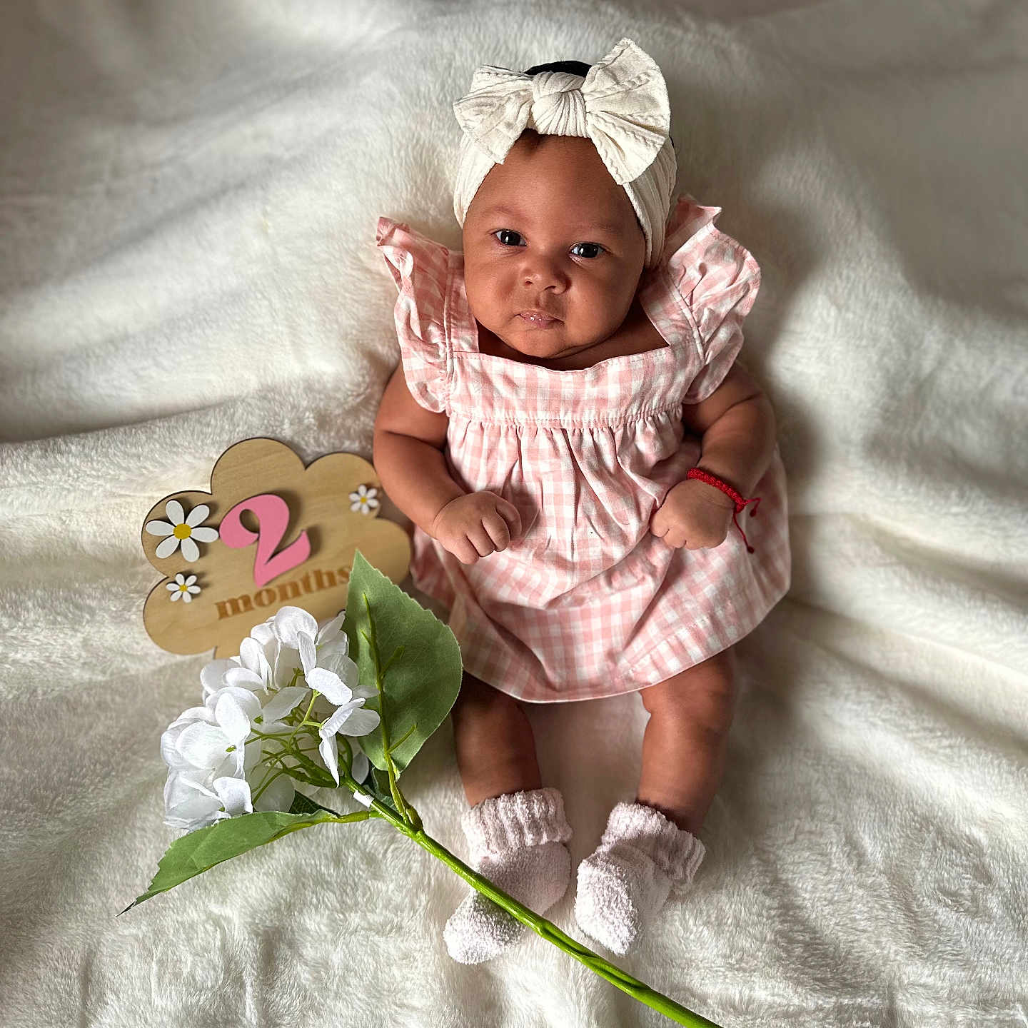 Kalaiah joined the competition — help win amazing prizes! baby, infant, girl, pink_dress, headband, bow, white_blanket, flower, wooden_sign, milestone, 2_months, socks, cute, portrait, smiling, sitting, indoors, soft_light, cozy, baby_photo