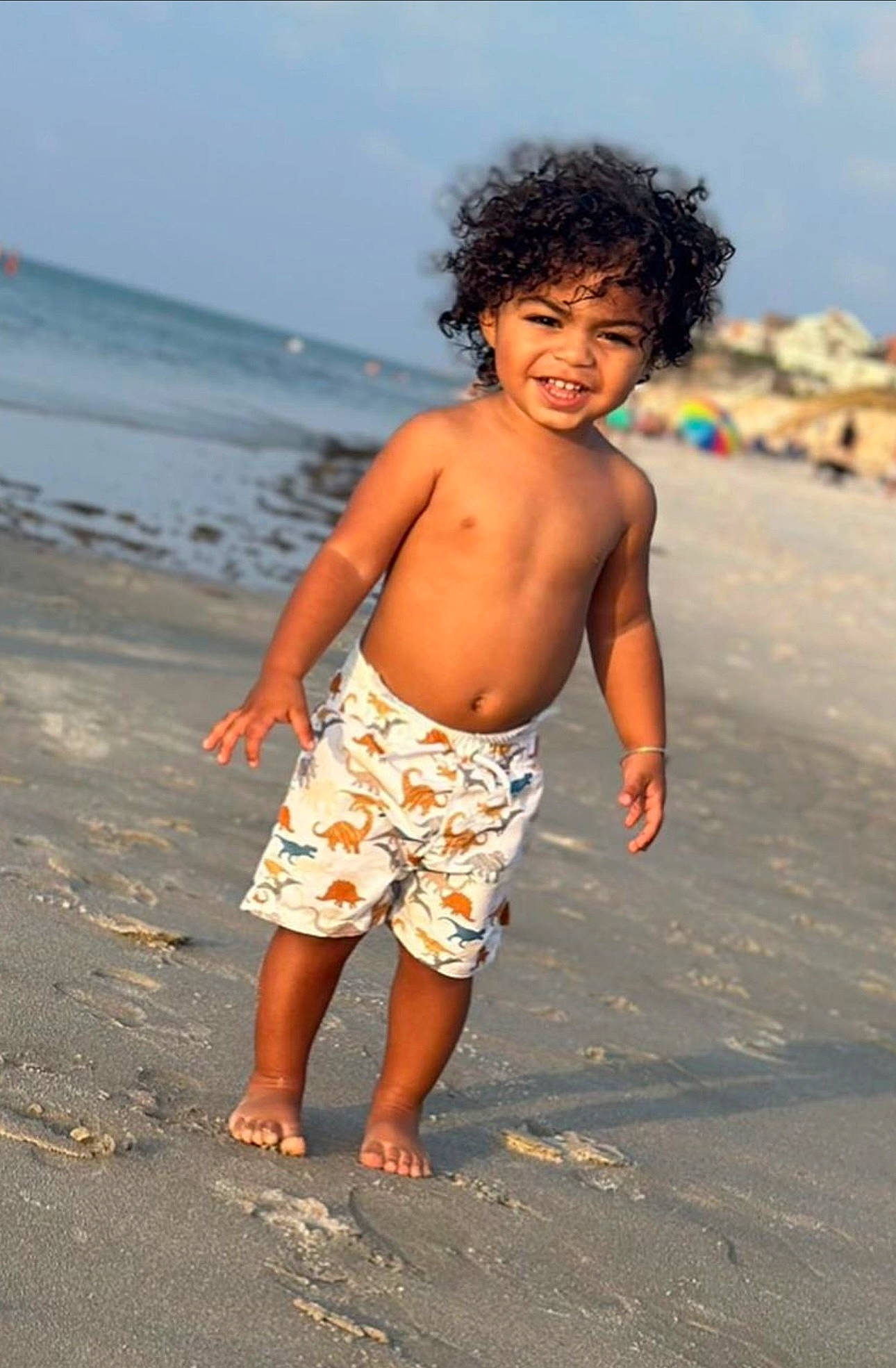 Braedyn is registered to the contest to win money with this photo: arm, barefoot, beach, bermuda_shorts, board_short, child, flash_photography, fun, happy, leisure, people_in_nature, people_on_beach, person, sand, shorts, sky, smile, summer, toddler, trunks