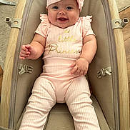 Taliah is registered to the contest to win money with this photo: baby, infant, smiling, pink_outfit, headband, baby_seat, cushion, wood_floor, happy, child, person, indoors, cute, portrait, clothing, baby_girl, seat_belt, soft_fabric, small_child, expression