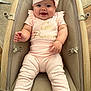 baby, infant, smiling, pink_outfit, headband, baby_seat, cushion, wood_floor, happy, child, person, indoors, cute, portrait, clothing, baby_girl, seat_belt, soft_fabric, small_child, expression