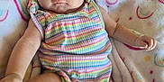 Joni is registered to the contest to win money with this photo: baby, infant, child, face, headband, flower, clothing, pastel_colors, rainbow, blanket, pattern, smiling_sun, cute, lying_down, soft_texture, indoors, person, skin, arm, leg