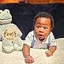 Kellan is registered to the contest to win money with this photo: baby, blanket, blue_background, bracelet, child, closeup, curious, cute, drool, fluffy, four_months, frog, indoors, infant, lying_down, plush_toy, portrait, soft_lighting, white_clothing, wooden_sign