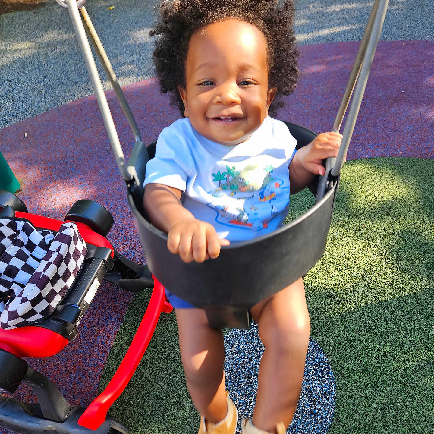 Kellan is registered to the contest to win money with this photo: child, curly_hair, daylight, footwear, fun, happy, leisure, outdoor, park, person, playground, playing, recreation, seat, shoes, smiling, sunlight, swing, toddler, toy