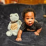 baby, black_hair, blanket, child, cozy, crawling, curious, cute, five_months, frog, indoor, infant, lying_down, person, plush_toy, smiling, soft_toy, stuffed_animal, wooden_background, young_child