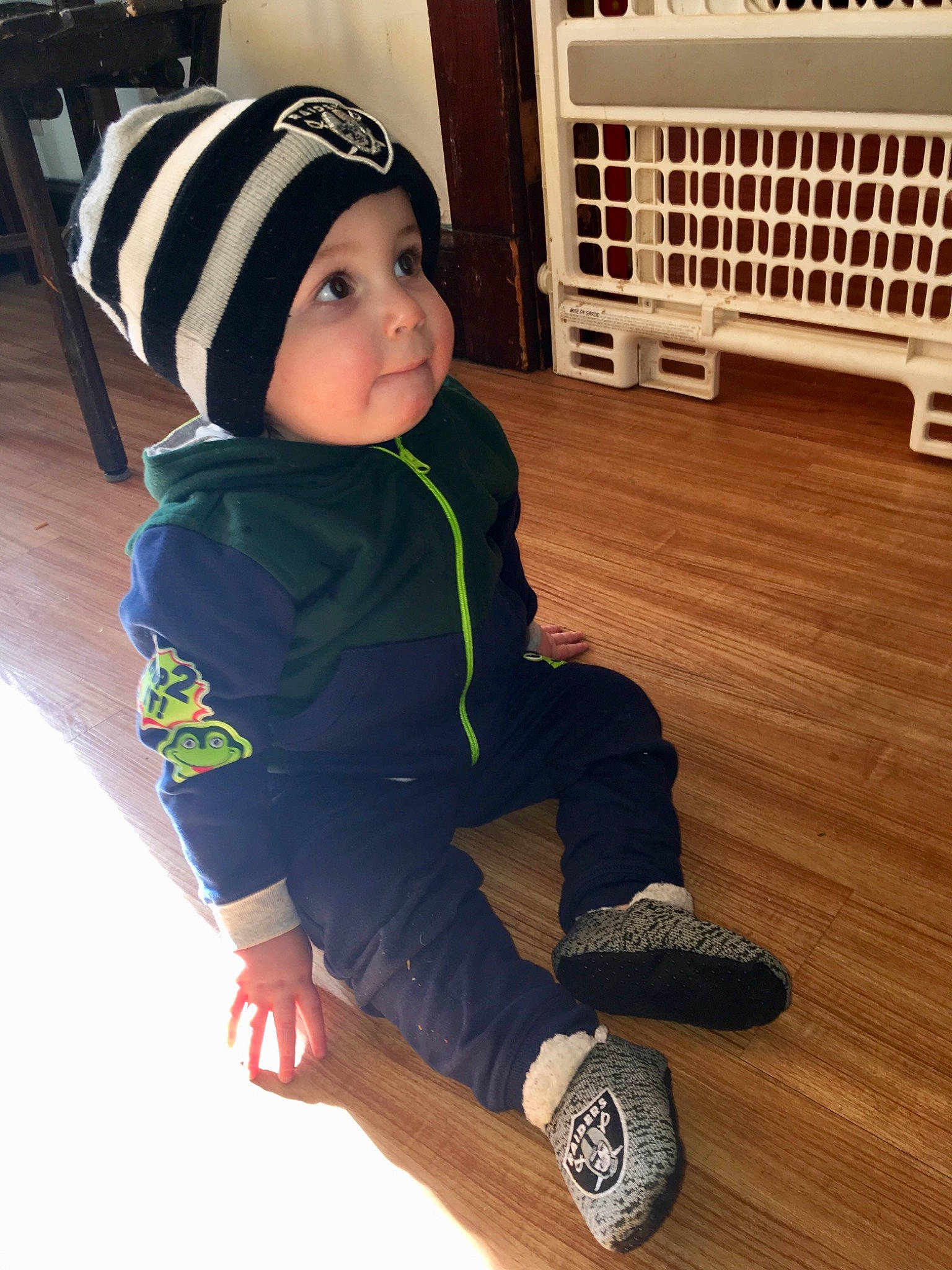 Kaidenn is registered to the contest to win money with this photo: beanie, cap, child, clothing, cool, floor, flooring, footwear, green, hardwood, head, headgear, hoodie, jeans, knit_cap, outerwear, person, smile, toddler, wood