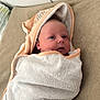 baby, beige, blanket, calm, child, curious, cute, expression, face, head, hooded_towel, indoor, infant, lying_down, newborn, person, skin, soft_texture, towel, wrapped