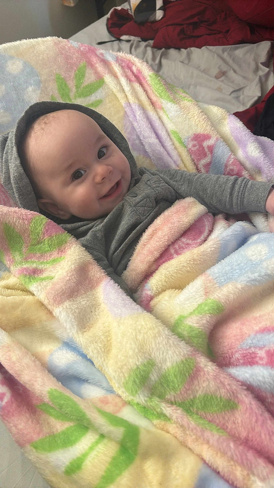 Ashton is registered to the contest to win money with this photo: baby, child, blanket, smile, hoodie, bed, cozy, infant, soft, happy, person, portrait, indoor, cute, warm, colorful, fabric, face, wrapped, comfort