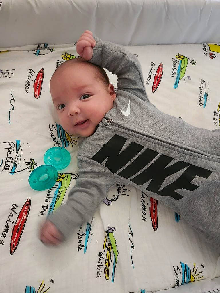 Elijah is registered to the contest to win money with this photo: baby, baby_products, baby_toddler_clothing, cheek, child, comfort, eye, face, font, happy, head, linens, pattern, person, product, room, sitting, sleeve, t_shirt, textile