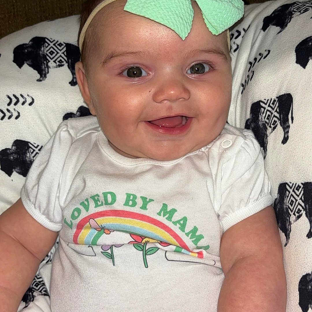 Maya joined the competition — help win amazing prizes! accessories, architecture, baby, building, clothing, couch, cushion, face, furniture, happy, head, homedecor, indoors, laughing, newborn, person, photography, portrait, smile, t_shirt