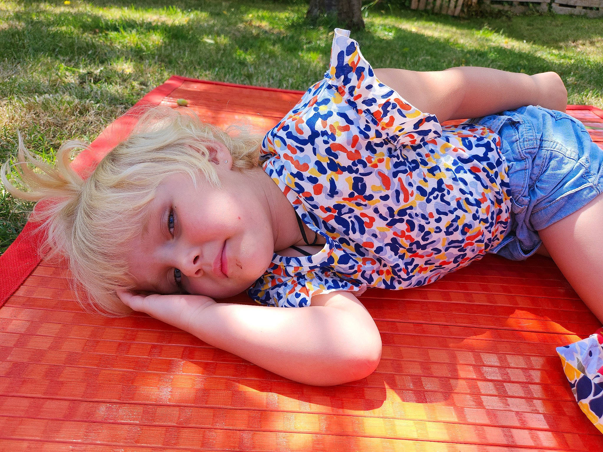 Ilyana a rejoint le concours — aidez-le/la à gagner de superbes lots ! barefoot, blond, child, electric_blue, flooring, fun, grass, happy, human_leg, joint, knee, leisure, pattern, people_in_nature, person, sitting, thigh, toddler, tree, vacation