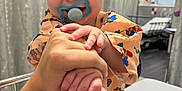 Adrian joined the competition — help win amazing prizes! baby, child, pacifier, hand, hospital, bed, curtain, person, smiling, clothing, indoor, adult, holding, cute, infant, healthcare, happy, room, toy_pattern, portrait