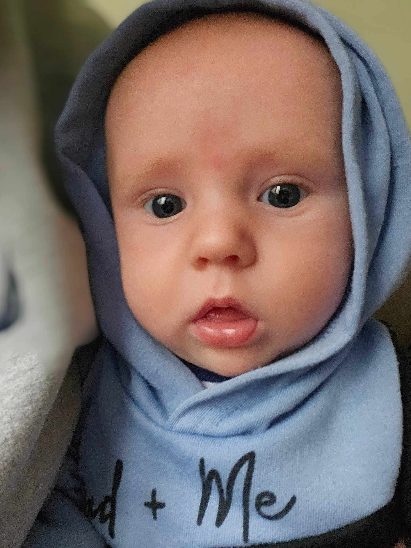 Tulsyn is registered to the contest to win money with this photo: baby, child, hoodie, blue_clothing, face, eyes, infant, curious, portrait, closeup, soft_light, expression, young, cute, skin, person, apparel, warm_clothing, indoors, headwear
