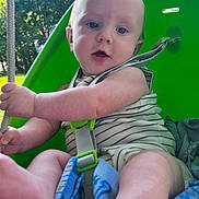 Tulsyn is registered to the contest to win money with this photo: baby, child, swing, outdoor, green, rope, nature, trees, blue_eyes, summer, play, seat, infant, curious, barefoot, striped_clothing, sunlight, daytime, happy, fun