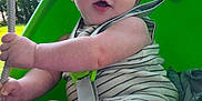 Tulsyn is registered to the contest to win money with this photo: baby, barefoot, blue_eyes, child, curious, daytime, fun, green, happy, infant, nature, outdoor, play, rope, seat, striped_clothing, summer, sunlight, swing, trees