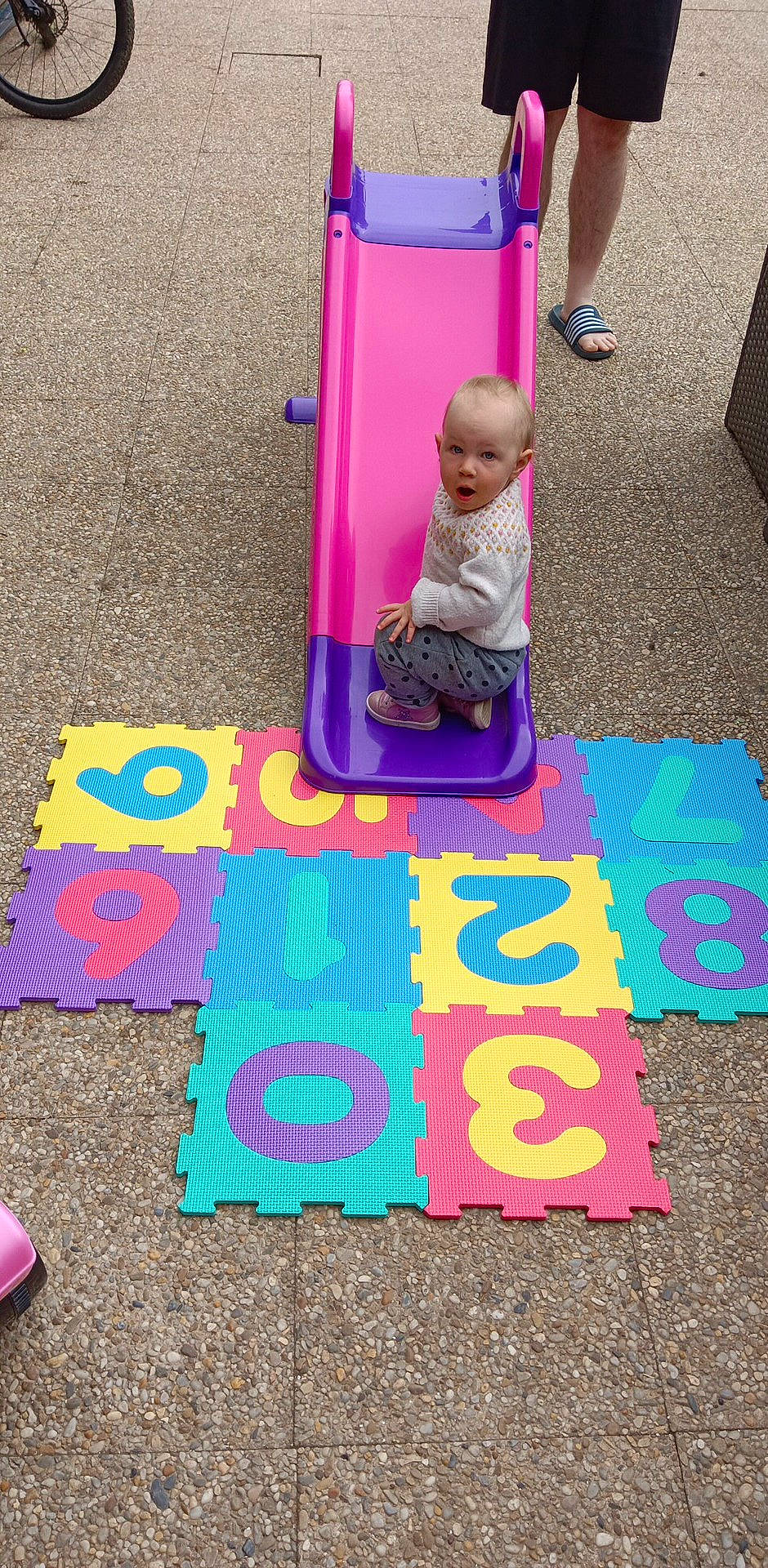 Layla participe au concours pour gagner de l'argent avec cette photo : asphalt, baby, child, floor, flooring, font, fun, grass, human_settlement, magenta, paint, person, pink, play, poster, public_space, purple, road_surface, shorts, sidewalk