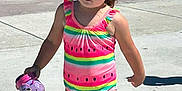 Hazelee joined the competition — help win amazing prizes! child, girl, swimsuit, watermelon_pattern, water_shoe, outdoor, splash_pad, concrete, sunny, hair_buns, playground, summer, water_play, footwear, walking, preschooler, casual, daylight, cute, toddler