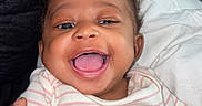 Shanell is registered to the contest to win money with this photo: baby, child, clothing, comfort, couch, cute, face, hand, happy, indoors, infant, joy, lying, person, pillow, relax, skin, smile, striped, young