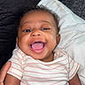 Shanell is registered to the contest to win money with this photo: baby, smile, infant, happy, person, face, hand, pillow, couch, clothing, striped, cute, child, lying, indoors, joy, skin, young, relax, comfort
