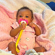 Shanell joined the competition — help win amazing prizes! baby, pacifier, blanket, pink_onesie, infant, soft_texture, cute, child, cozy, indoors, portrait, sleepwear, toddler, wrapped, clothing, baby_girl, plush, comfort, face, small_hands