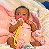 baby, pacifier, blanket, pink_onesie, infant, soft_texture, cute, child, cozy, indoors, portrait, sleepwear, toddler, wrapped, clothing, baby_girl, plush, comfort, face, small_hands