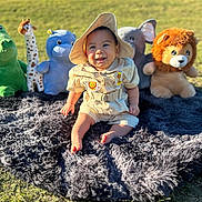 Christopher is registered to the contest to win money with this photo: baby, child, crocodile, cute, elephant, giraffe, grass, happy, hat, hippo, lion, nature, outdoor, playtime, plush_toys, rug, sitting, smiling, stuffed_animals, sunlight