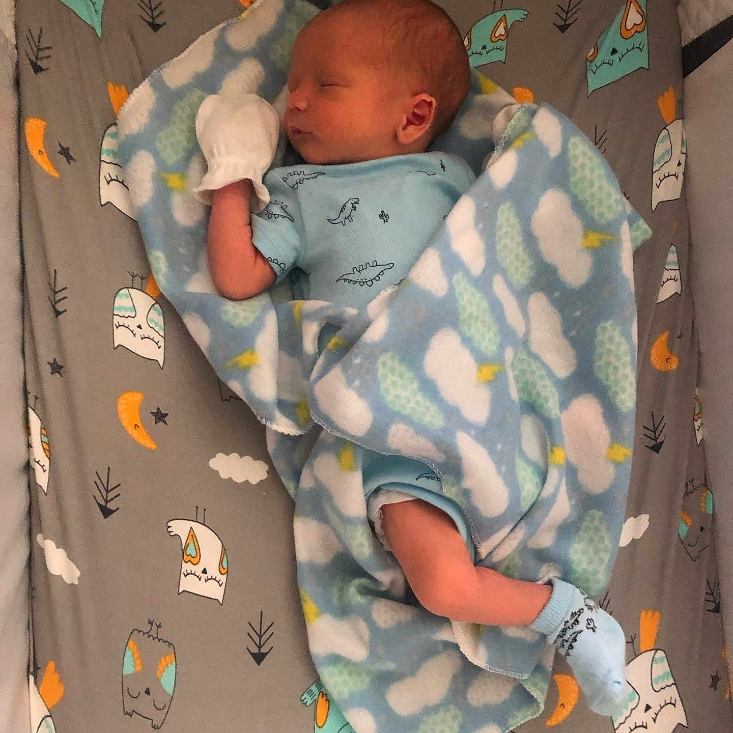 Gabriel is registered to the contest to win money with this photo: baby, bed, blanket, clothing, crib, face, furniture, glove, head, infantbed, newborn, person, skin, tattoo