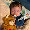 baby, sleeping, pacifier, teddy_bear, stuffed_animal, blanket, cozy, child, infant, cute, soft, comfort, home, clothing, face, portrait, resting, warm, person, toy