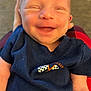 Amir joined the competition — help win amazing prizes! baby, smiling, infant, clothing, navy_blue, checkered_flag, happy, face, head, person, human, arms, skin, toddler, closeup, portrait, cute, newborn, sitting, indoor