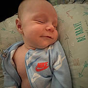 Amir joined the competition — help win amazing prizes! baby, sleeping, blue_jacket, nike, pillow, text_on_pillow, infant, smiling, clothing, bedtime, cute, peaceful, portrait, closeup, indoor, child, resting, soft_lighting, young, cozy