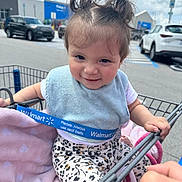 Alorah is registered to the contest to win money with this photo: toddler, child, shopping_cart, walmart, blanket, bib, parking_lot, car, hand, clothing, hair, smile, outdoor, baby, seat_belt, person, toy, cute, expression, sitting